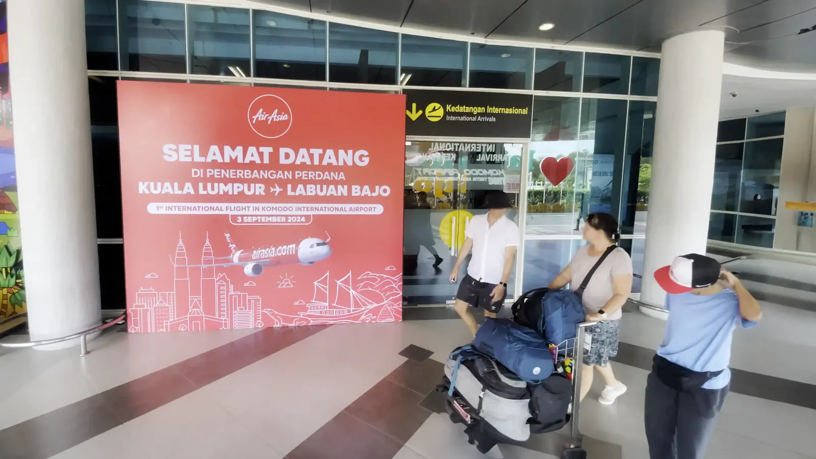 Travellers with luggage trolleys at the international arrivals entrance of Komodo Airport, Labuan Bajo